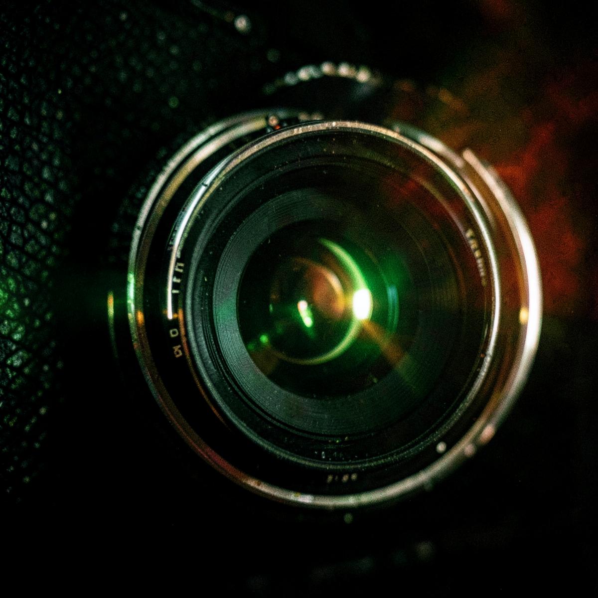 Close-up of a camera lens catching light